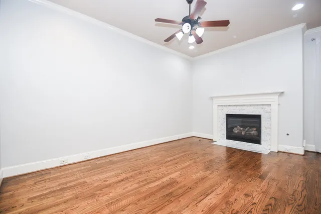 wooden floor chandelier fan and windows in a room