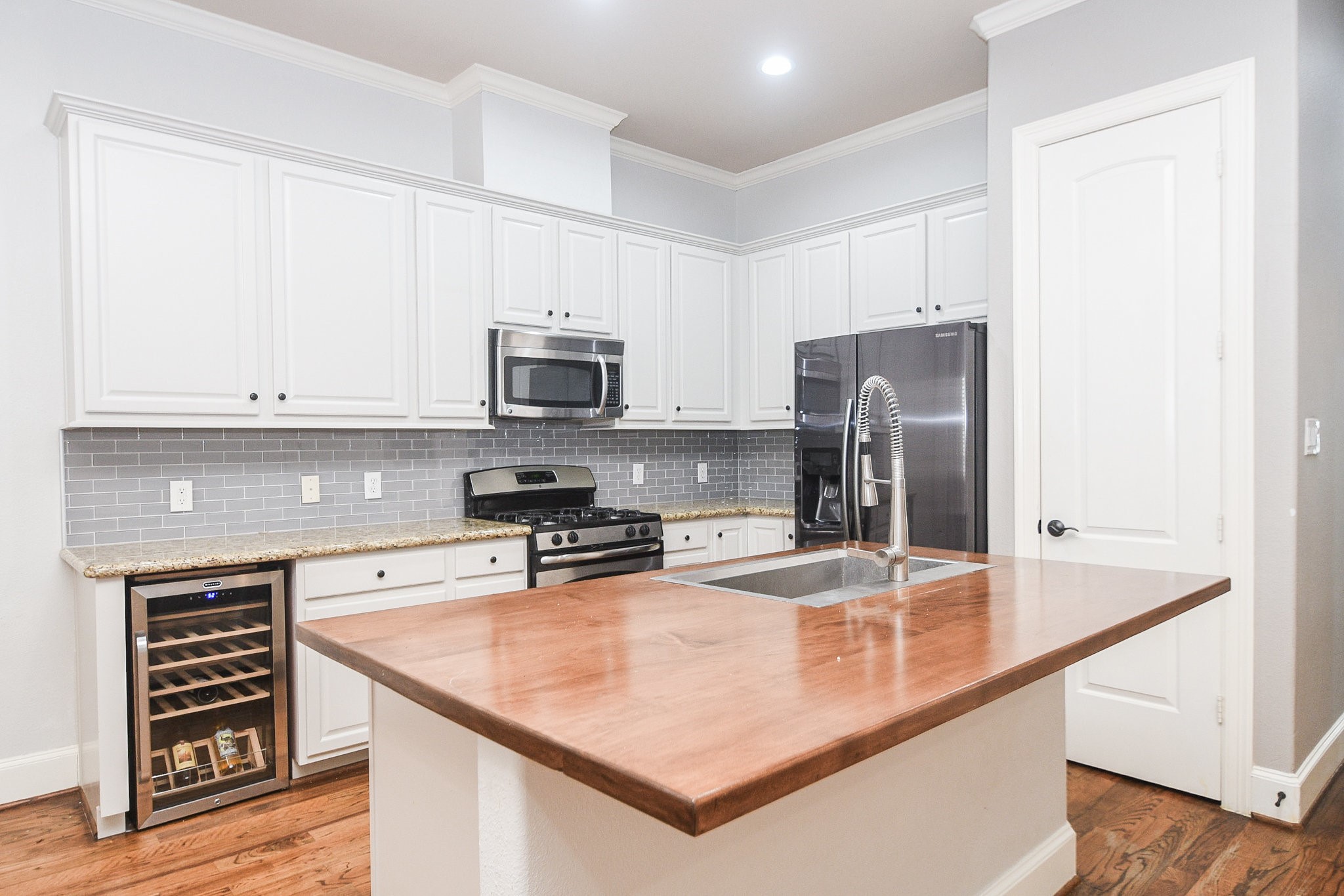 1222 West 17th Street, Unit D Houston, TX 77008 - Photo 9 of 35 a kitchen with kitchen island a counter appliances and cabinets