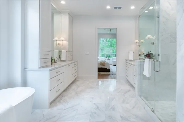 a spacious bathroom with a double vanity sink a mirror and a shower