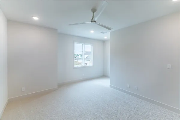 an empty room with windows and chandelier fan