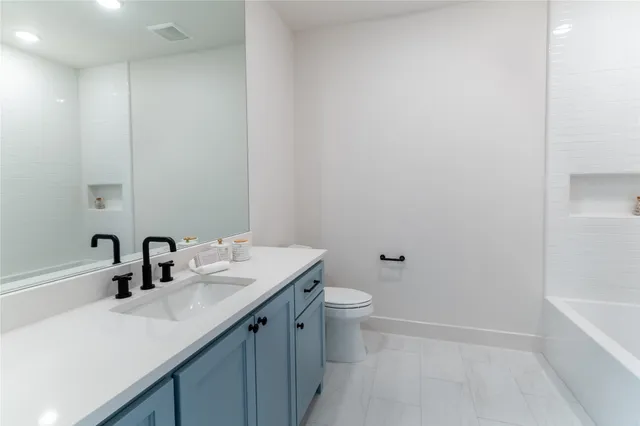 a bathroom with a sink a toilet and bathtub