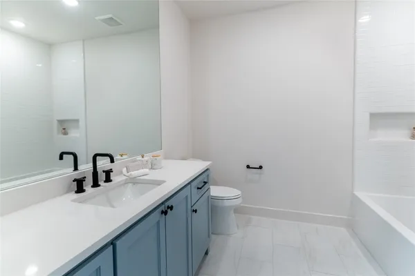 a bathroom with a sink a toilet and bathtub