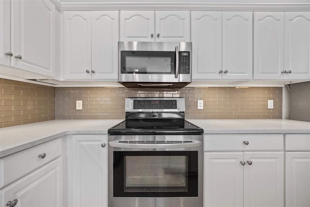 20907 Tangor Road Land O Lakes, FL 34637 - Photo 11 of 49 a kitchen with stainless steel appliances granite countertop white cabinets and a stove a sink