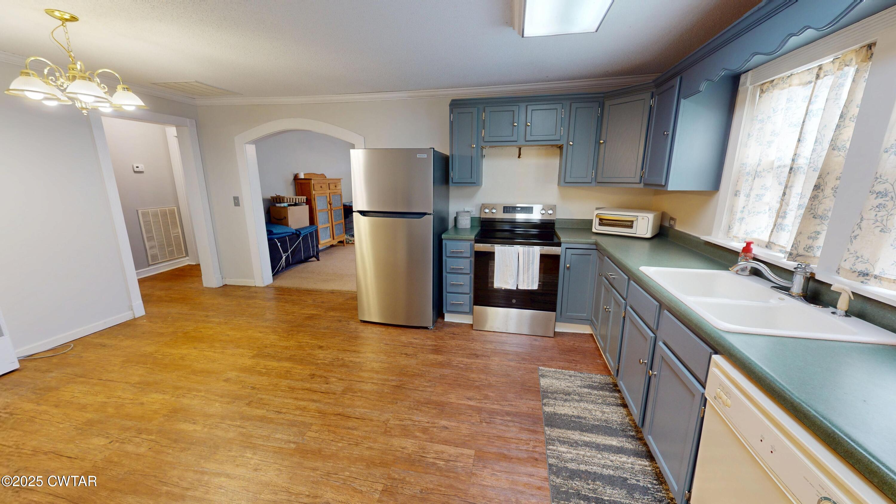 429 Church Street Ridgely, TN 38080 - Photo 12 of 35 a kitchen with stainless steel appliances granite countertop a refrigerator a stove top oven a sink dishwasher and wooden cabinets