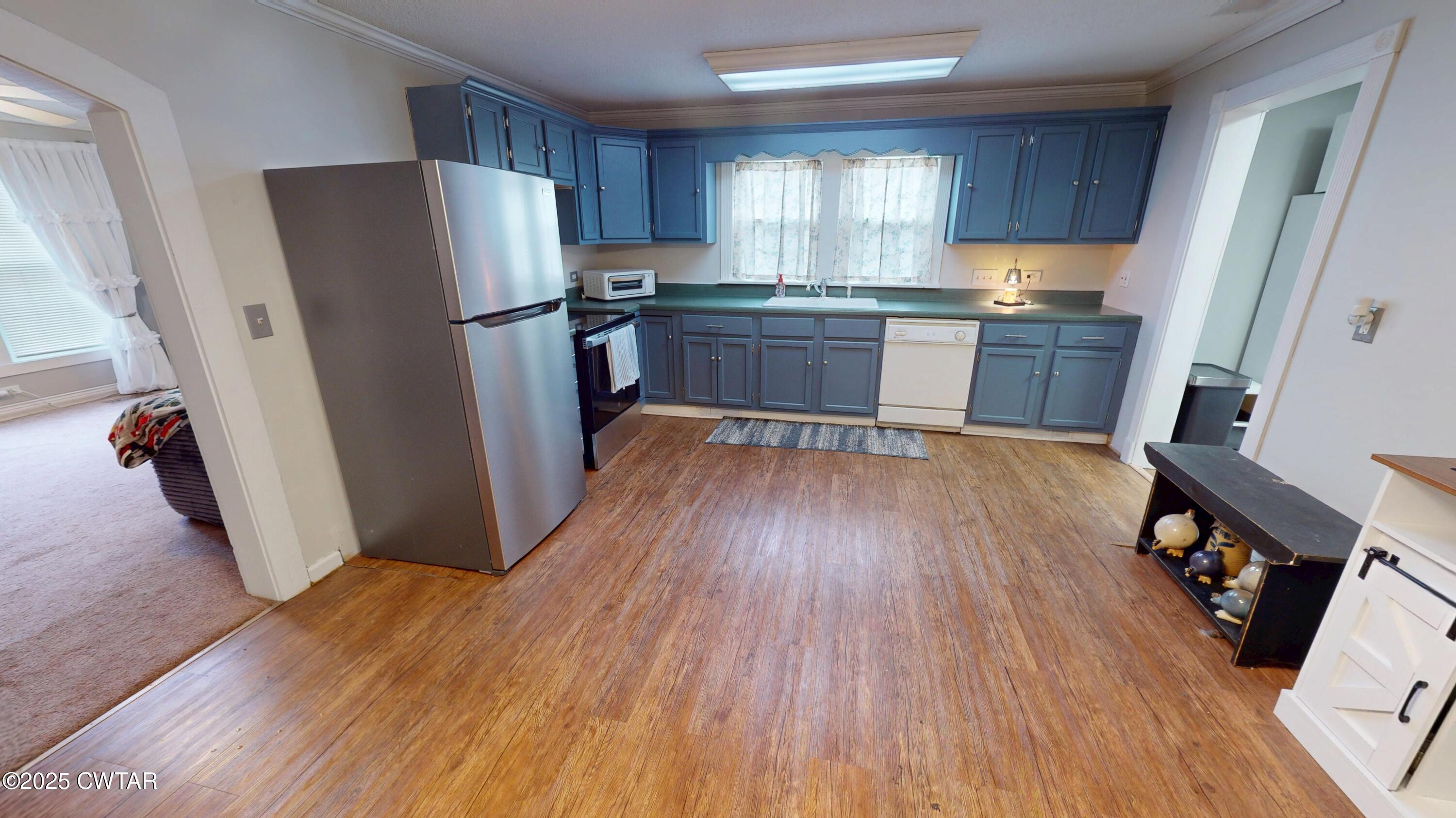 429 Church Street Ridgely, TN 38080 - Photo 8 of 35 a kitchen with stainless steel appliances wooden floors and wooden cabinets