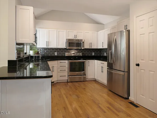 a kitchen with stainless steel appliances granite countertop a stove and a refrigerator