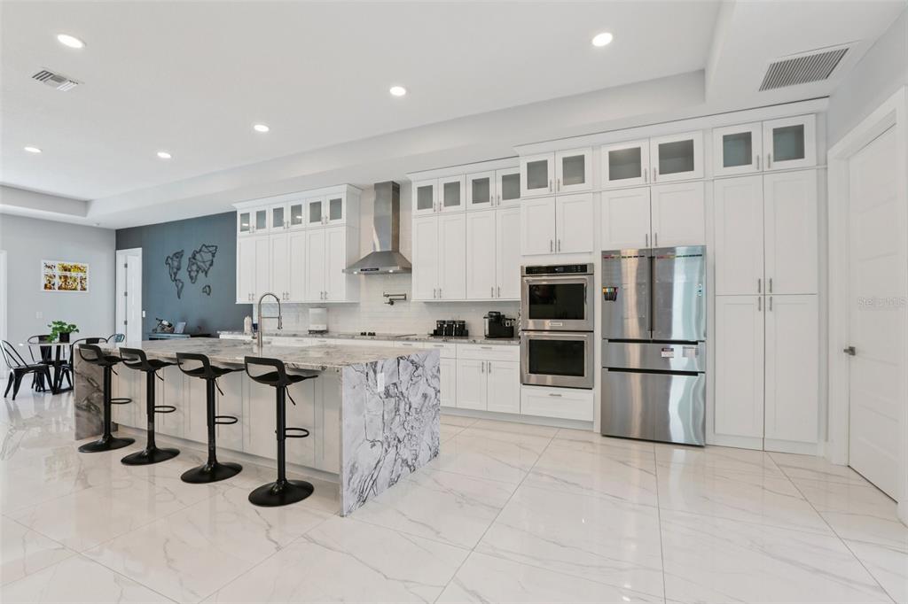 352 Mehlenbacher Road Belleair, FL 33756 - Photo 22 of 88 a kitchen with stainless steel appliances kitchen island granite countertop a table and chairs in it