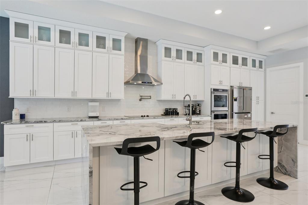 352 Mehlenbacher Road Belleair, FL 33756 - Photo 24 of 88 a kitchen with stainless steel appliances granite countertop a stove top oven a refrigerator a sink and white cabinets