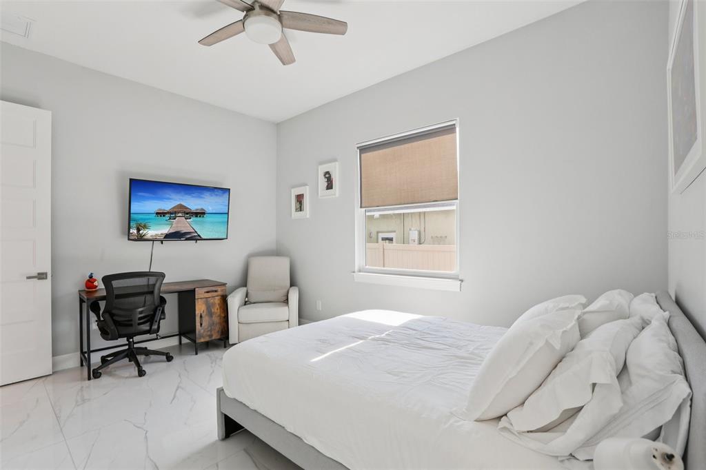 352 Mehlenbacher Road Belleair, FL 33756 - Photo 38 of 88 a bedroom with a bed a desk and chair with a bookshelf