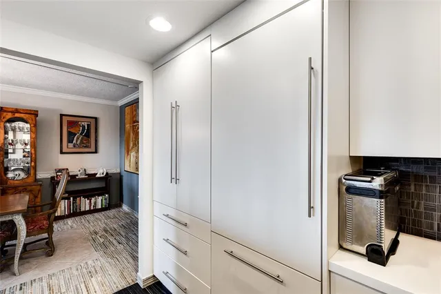 a kitchen with white cabinets and wooden floor