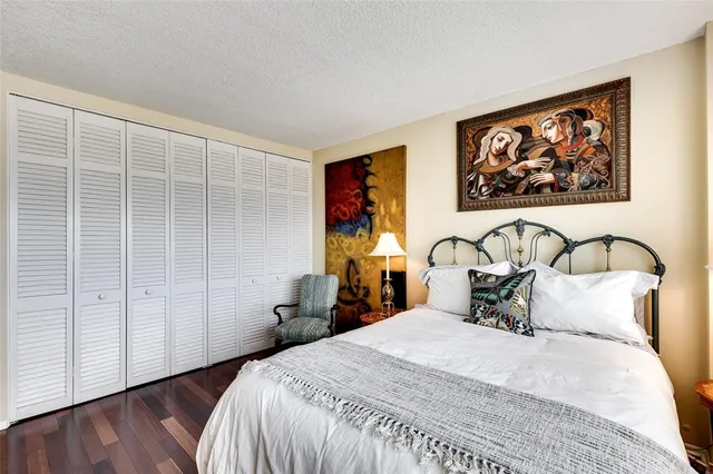 a bedroom with a bed and a painting on the wall