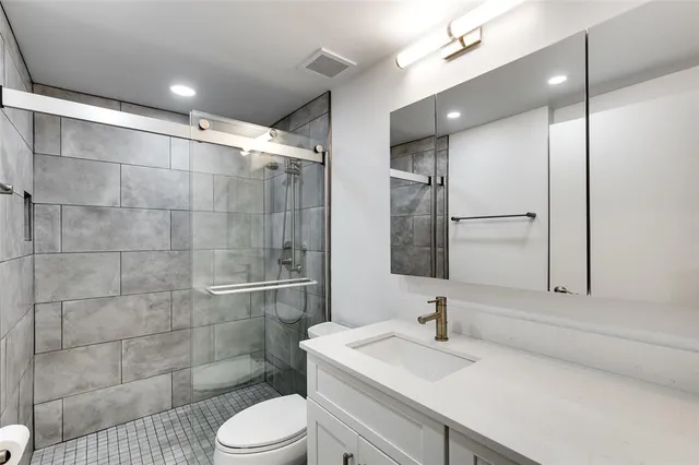 a bathroom with a sink toilet a mirror and shower