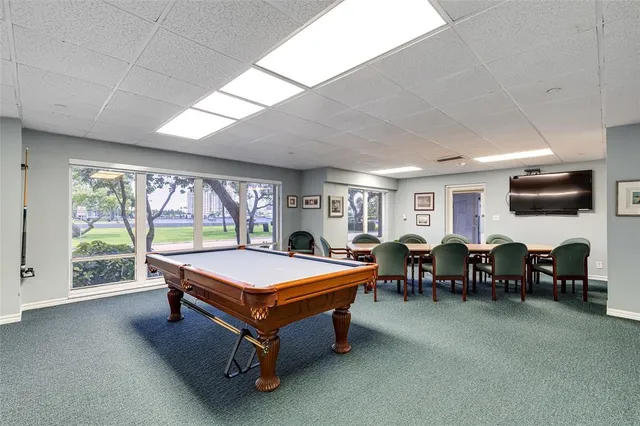 a room with pool table and windows