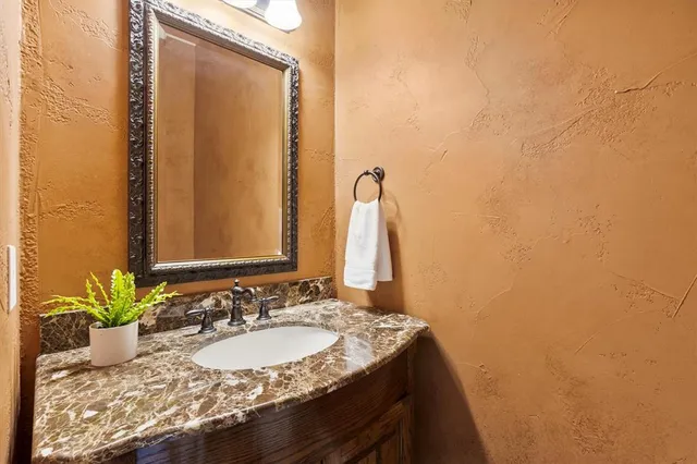 a bathroom with a granite countertop sink and a mirror
