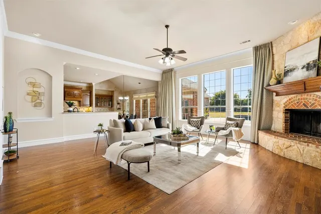 a living room with furniture large window and wooden floor