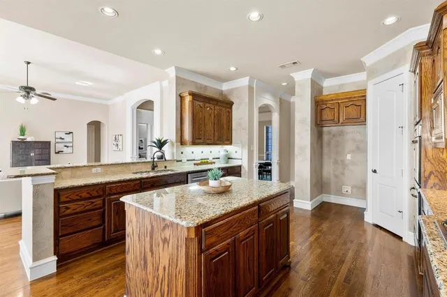 a spacious kitchen with stainless steel appliances granite countertop a stove and a sink