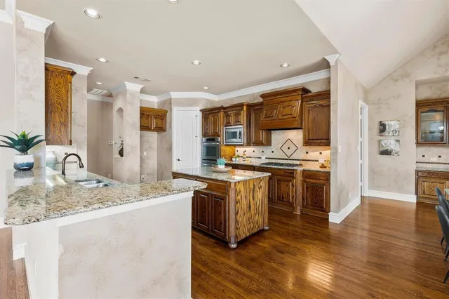 a kitchen with stainless steel appliances granite countertop a sink stove and refrigerator