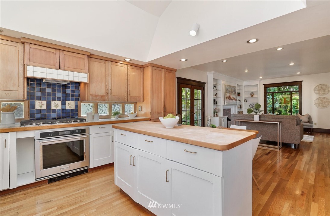 5124 1st Avenue Northwest Seattle, WA 98103 - Photo 12 of 35 a kitchen with stainless steel appliances kitchen island granite countertop a stove a sink and a refrigerator