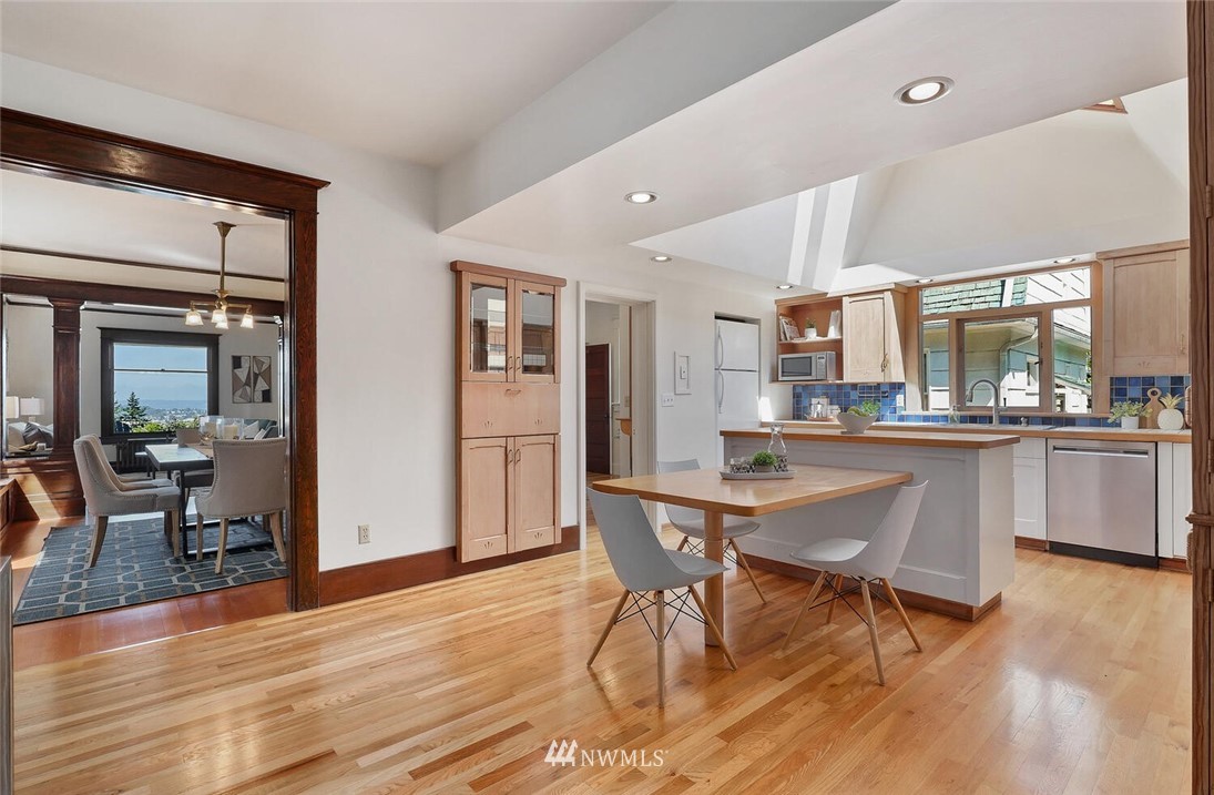 5124 1st Avenue Northwest Seattle, WA 98103 - Photo 9 of 35 a dining room with stainless steel appliances kitchen island granite countertop furniture and wooden floor