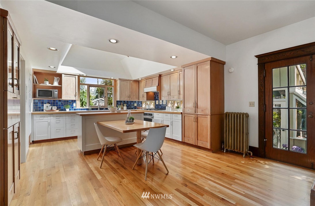 5124 1st Avenue Northwest Seattle, WA 98103 - Photo 10 of 35 a kitchen with a table chairs refrigerator and window