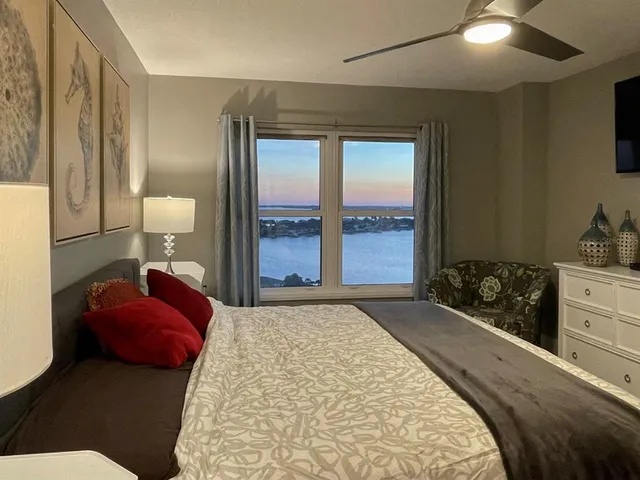 a bedroom with a bed and a dresser with mirror