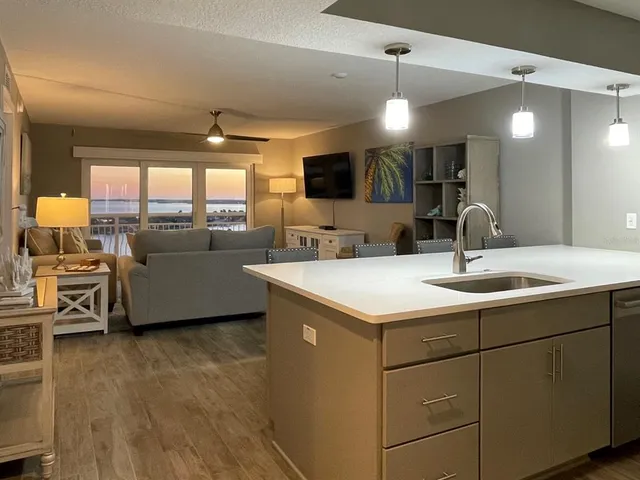 a kitchen with a sink and living room view