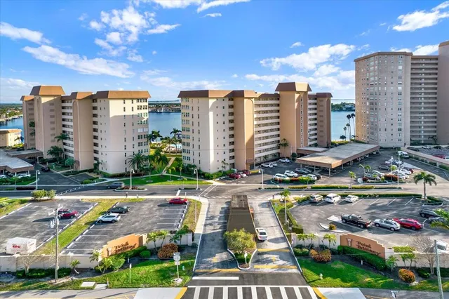 an aerial view of ocean and residential houses with outdoor space
