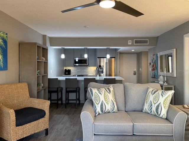 a living room with furniture kitchen view and a window