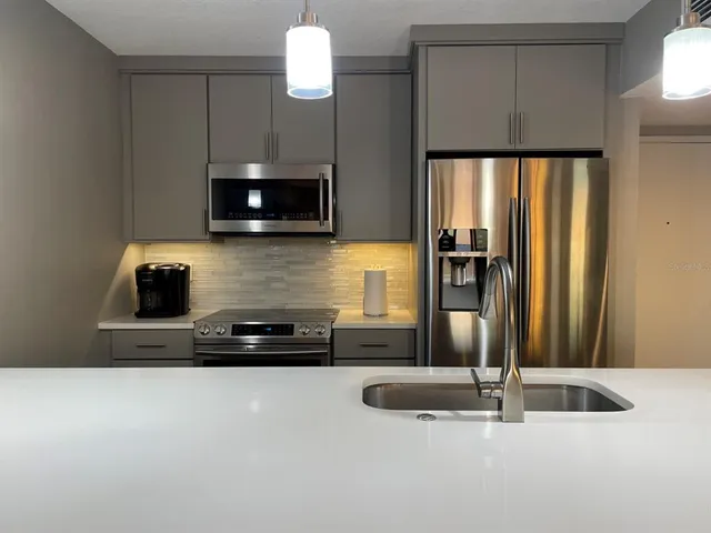 a kitchen with a sink a microwave a refrigerator and a stove