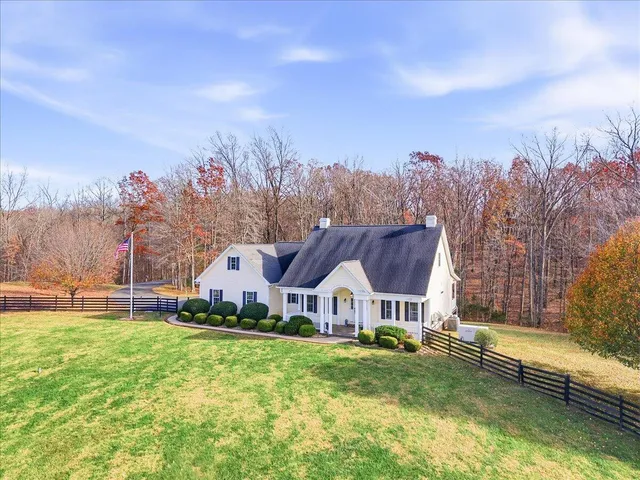 a view of a house with a big yard and large trees
