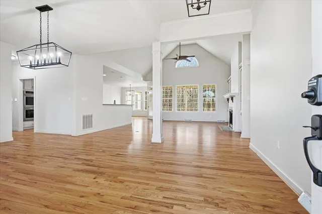 a view of empty room with window and wooden floor