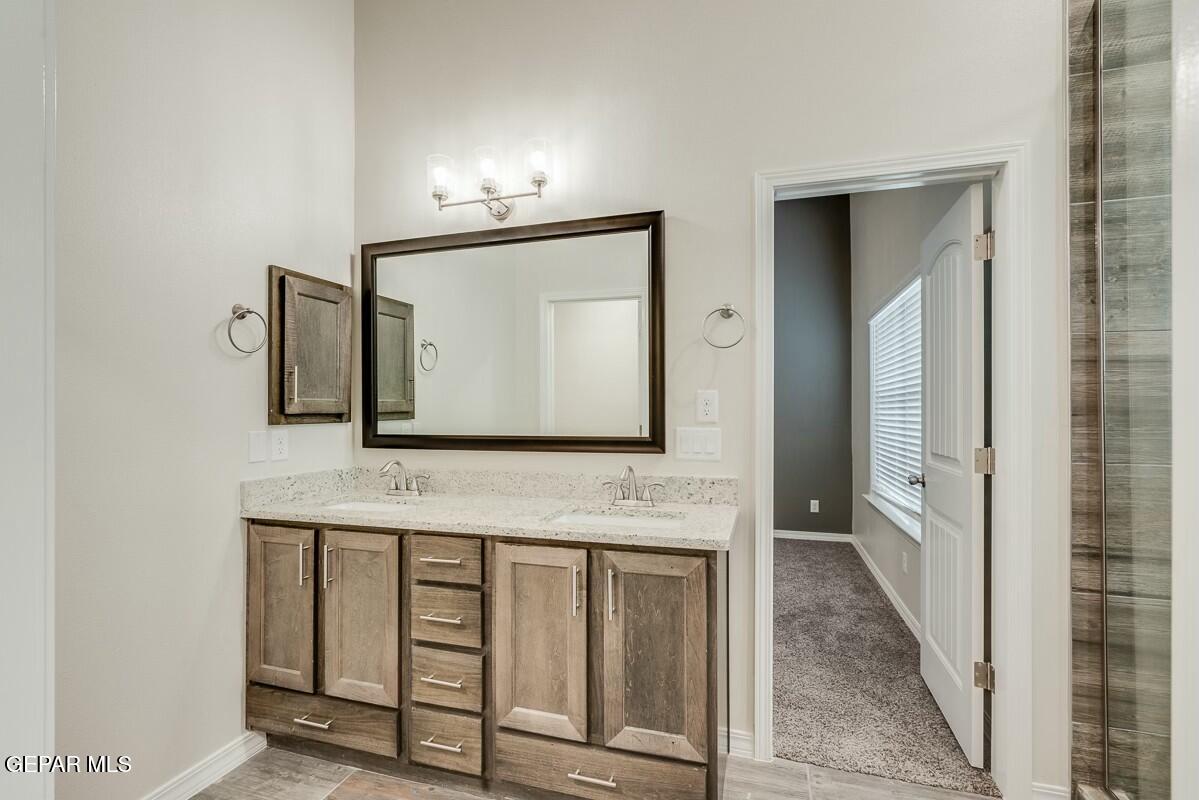6058 Fall Ridge Street Sunland Park, NM 88008 - Photo 23 of 26 a bathroom with mirror sink and vanity