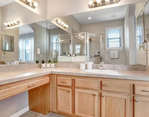 a bathroom with a sink a large mirror and vanity