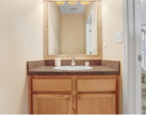 a bathroom with a granite countertop sink and a mirror