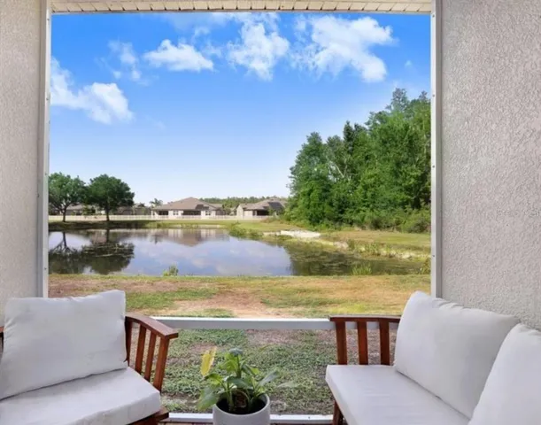 a view of a lake with couches in wooden floor