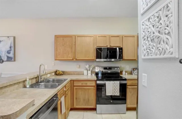 a kitchen with stainless steel appliances granite countertop a sink stove and microwave