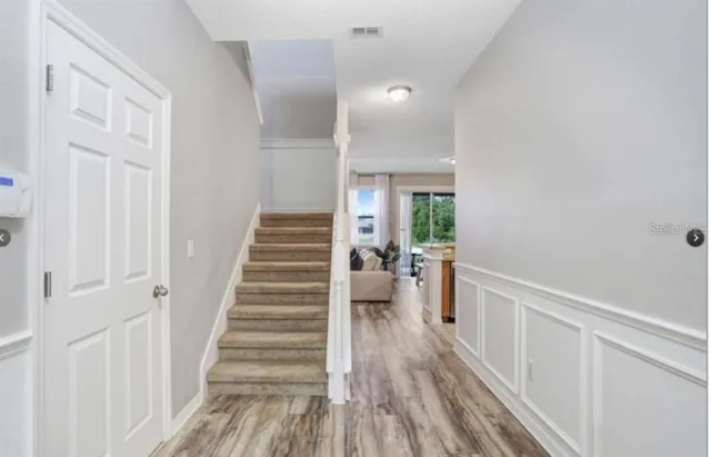 a view of a hallway with wooden floor and entryway