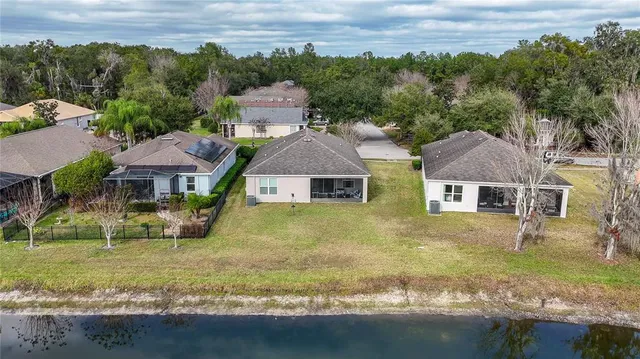 an aerial view of residential houses with outdoor space and trees