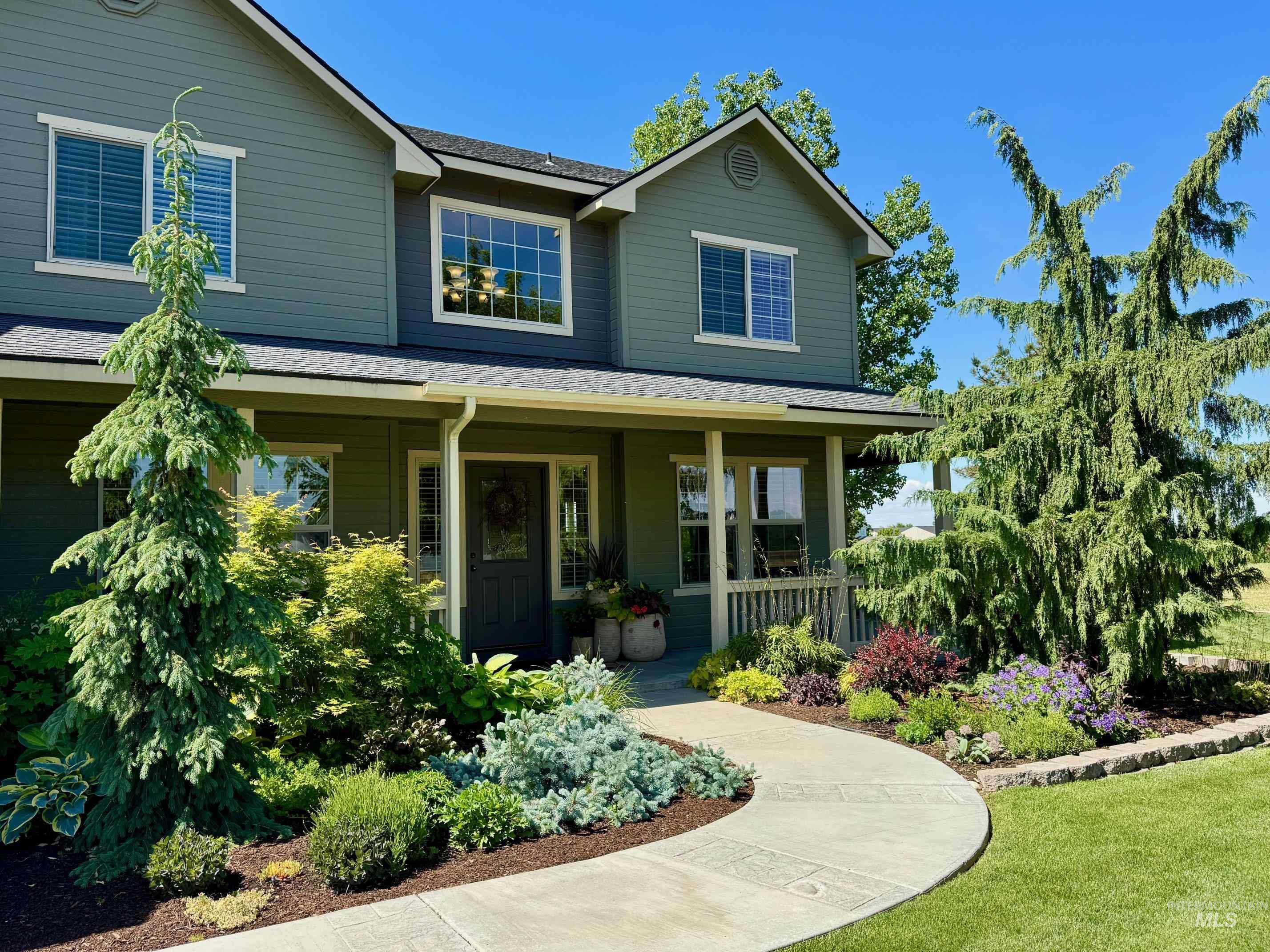 9299 Kemp Road Middleton, ID 83644 - Photo 43 of 50 Two-story residence featuring a covered front porch, dark gray siding, and white trim