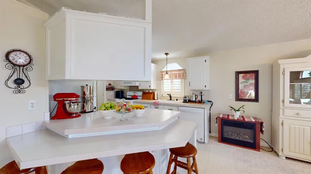 a view of a kitchen with kitchen island a sink stainless steel appliances and cabinets