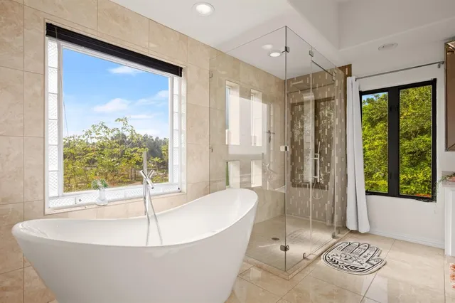 a white bath tub sitting in a bathroom next to a window