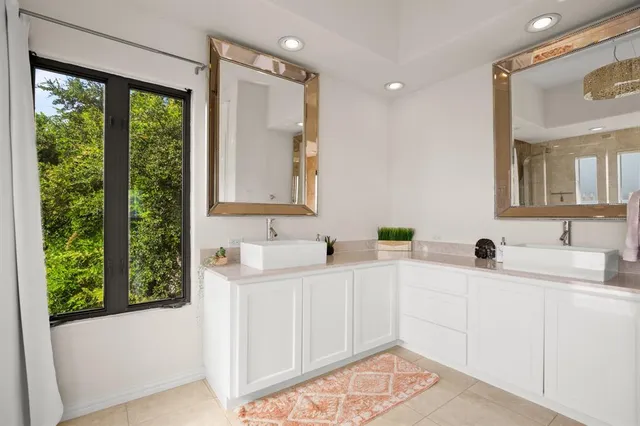 a bathroom with a double vanity sink a mirror and a shower