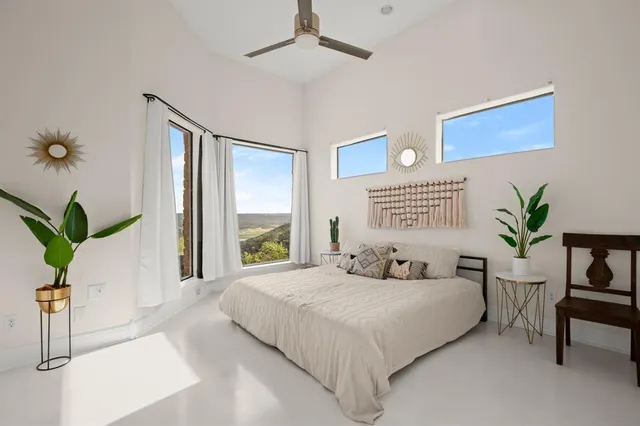 a bedroom with a large bed and a potted plant