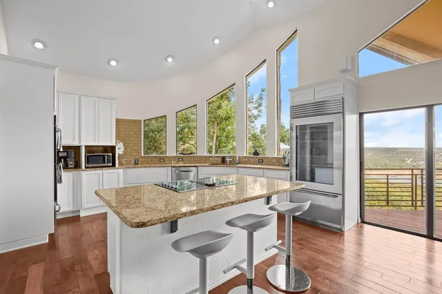 a dining hall with stainless steel appliances granite countertop a coffee table and chairs