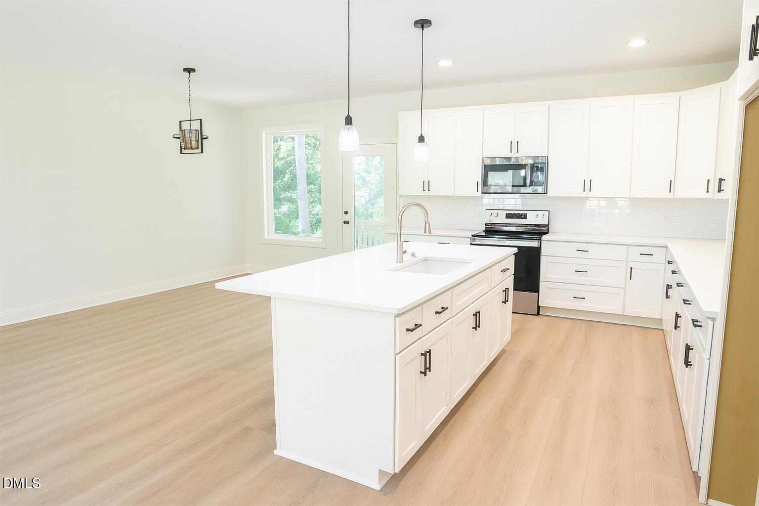 3345 Fleming Graham Road Burlington, NC 27217 - Photo 3 of 12 a kitchen with stainless steel appliances a white stove top oven a sink a chimney and a refrigerator