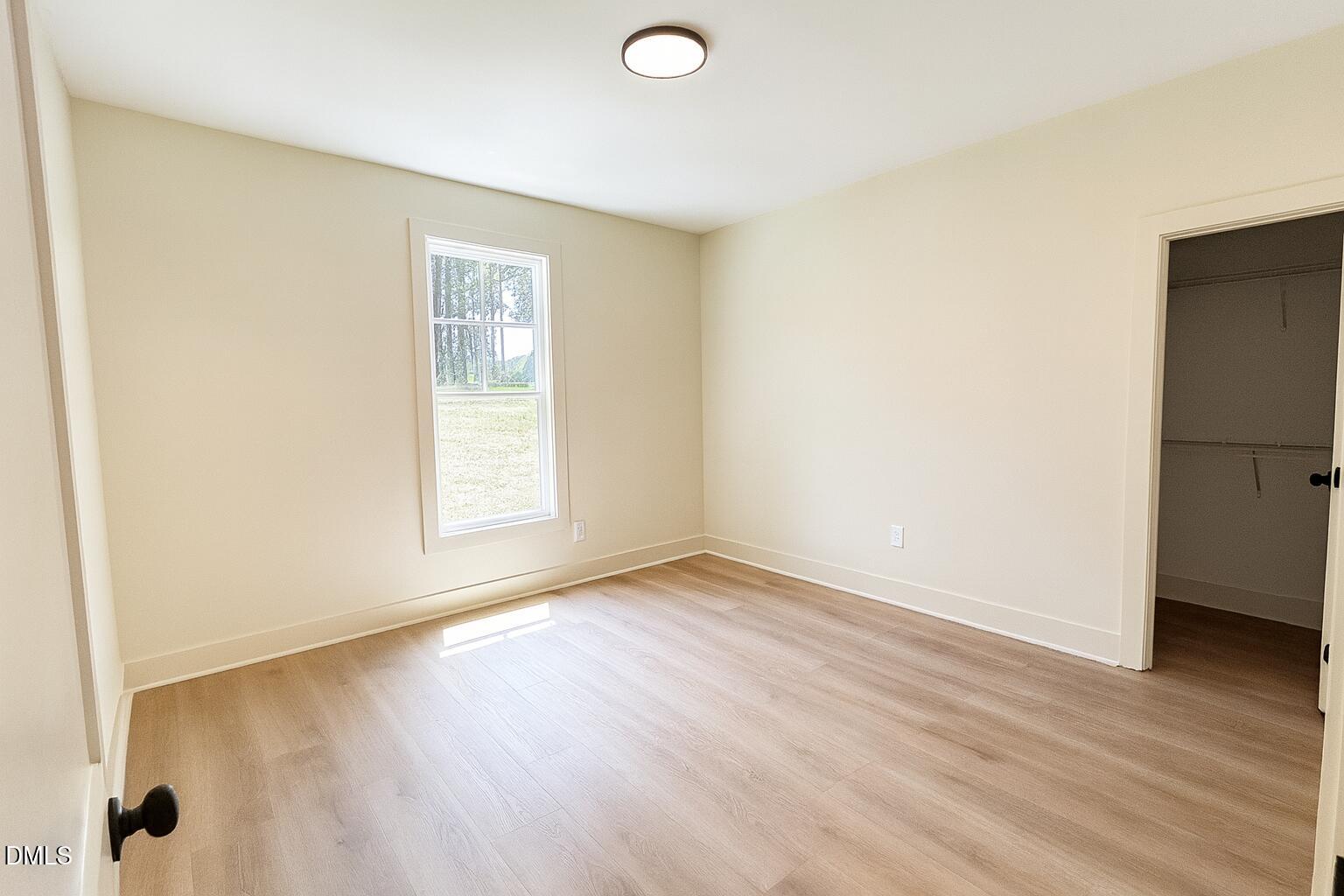 3345 Fleming Graham Road Burlington, NC 27217 - Photo 7 of 12 an empty room with wooden floor and windows