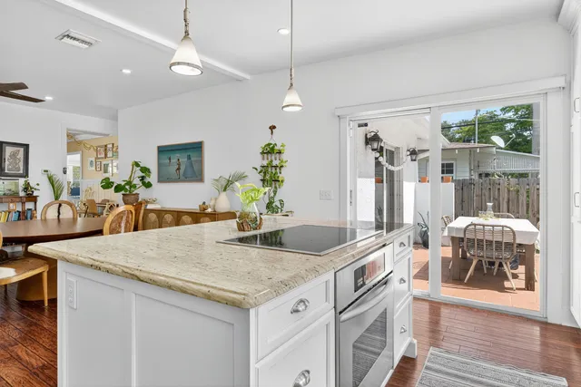 a kitchen with granite countertop a dining table chairs and white cabinets