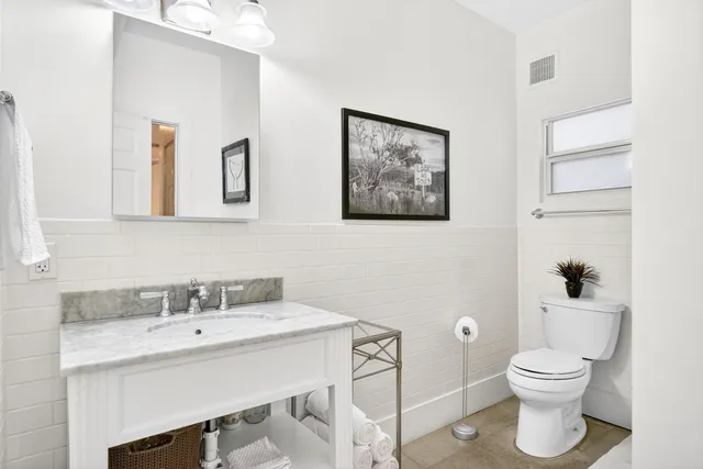 a bathroom with a toilet a sink and mirror