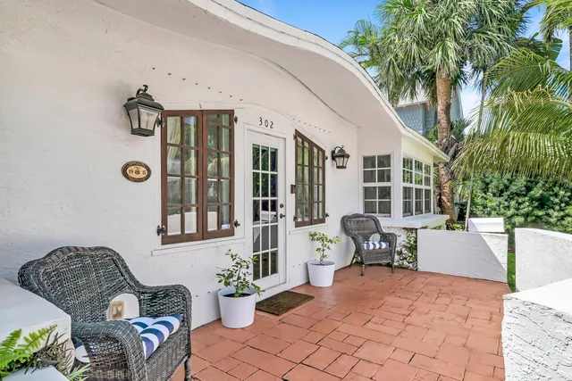 a view of a patio with couches table and chairs and potted plants