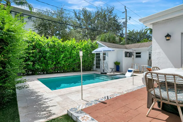 a patio with a table and chairs and potted plants
